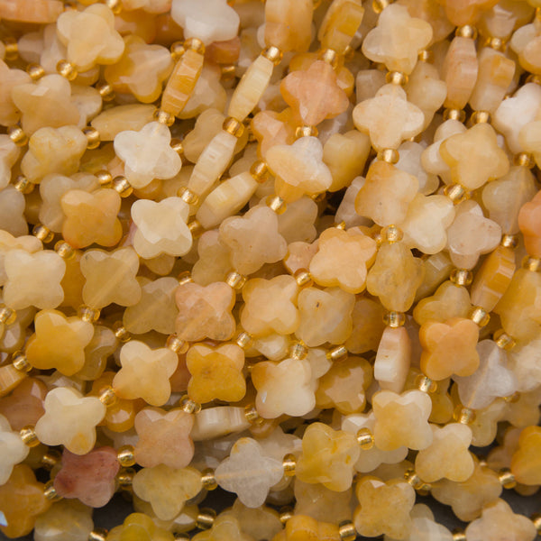 Faceted yellow jade clover beads in warm golden-yellow and creamy white tones with gold spacers.