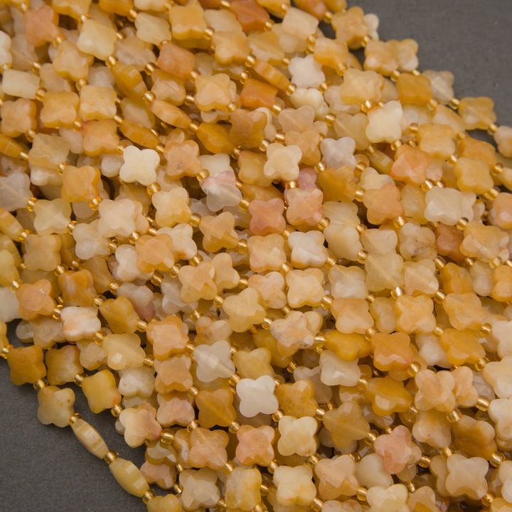 Yellow jade gemstone beads featuring four-petal floral shapes and a soft frosted finish.