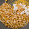 Close-up of faceted yellow jade clover beads with subtle color variations and delicate gold spacers.