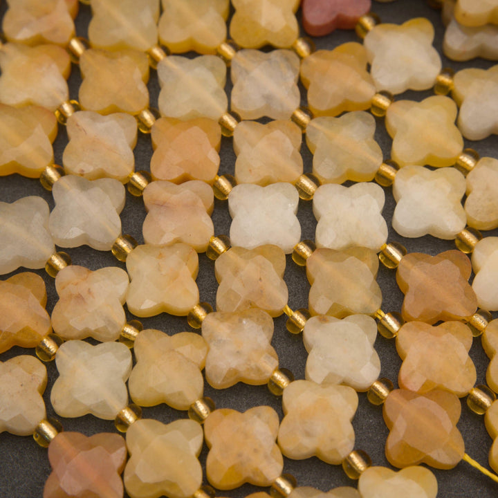 Yellow jade gemstone beads in decorative four-leaf clover shapes with faceted surfaces and a matte appearance.