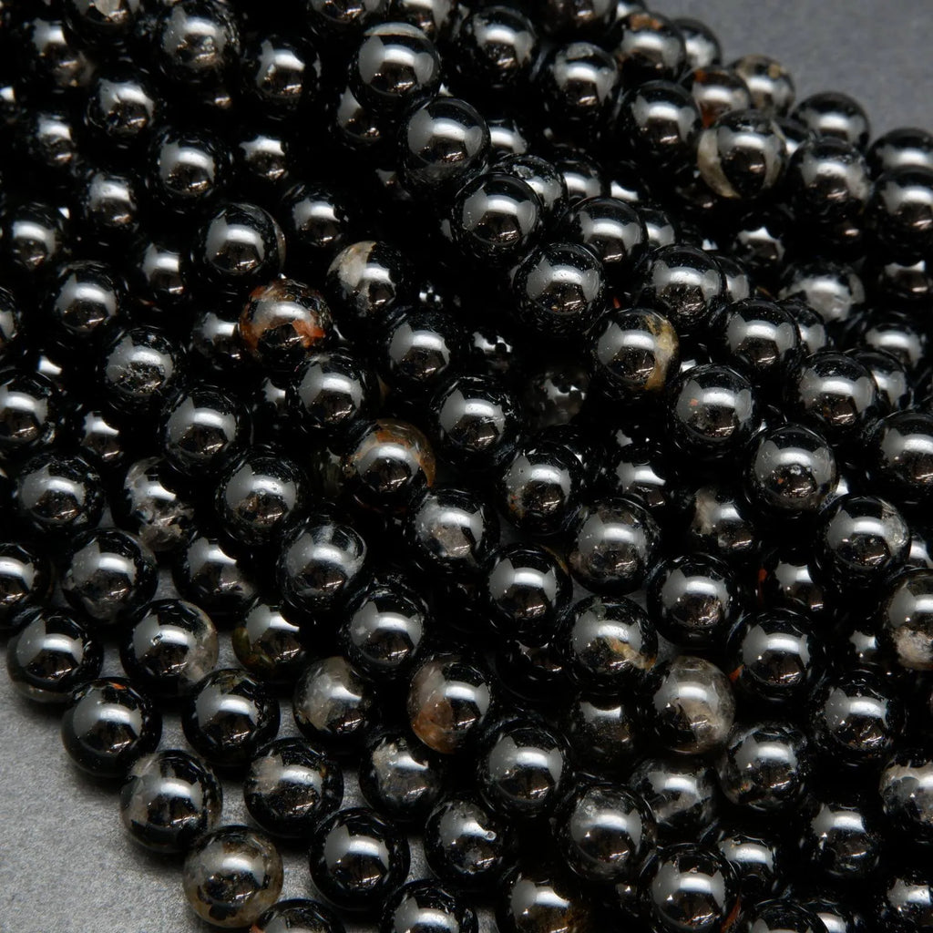 Black tourmaline beads with hematite inclusions.