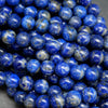Blue round lapis lazuli beads with calcite and pyrite inclusions.