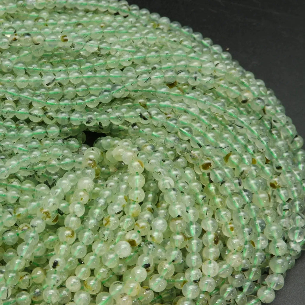 Green prehnite bead with epidote inclusions.