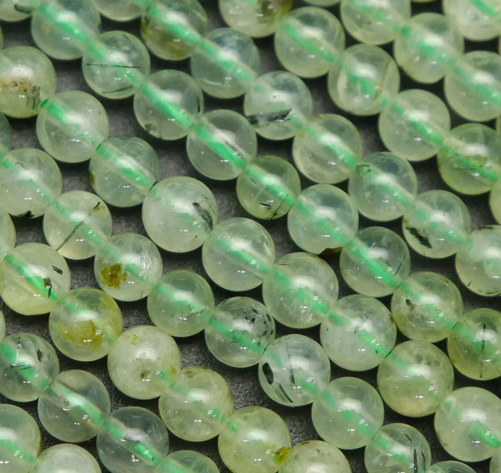 Green prehnite bead with epidote inclusions.