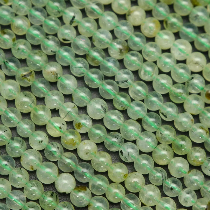 Green prehnite bead with epidote inclusions.