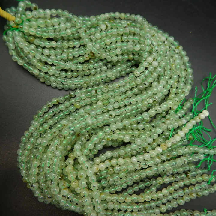 Green prehnite bead with epidote inclusions.