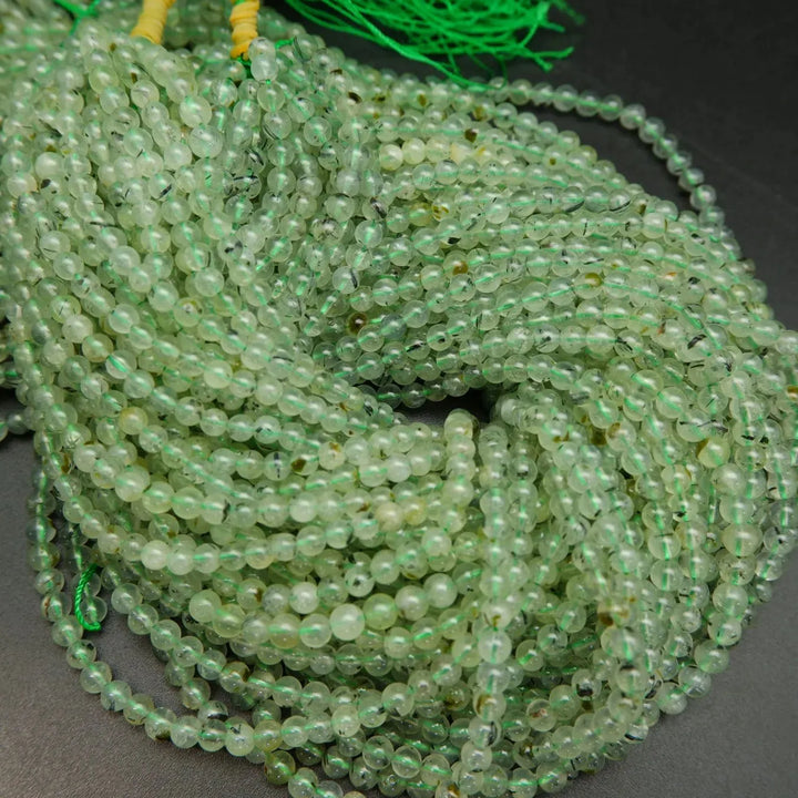 Green prehnite bead with epidote inclusions.