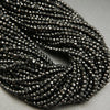 Faceted round black spinel beads on a string.