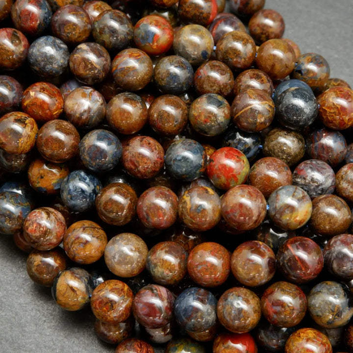 Brown, blue, and red round polished pietersite beads.