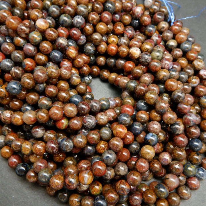 Brown, blue, and red round polished pietersite beads.