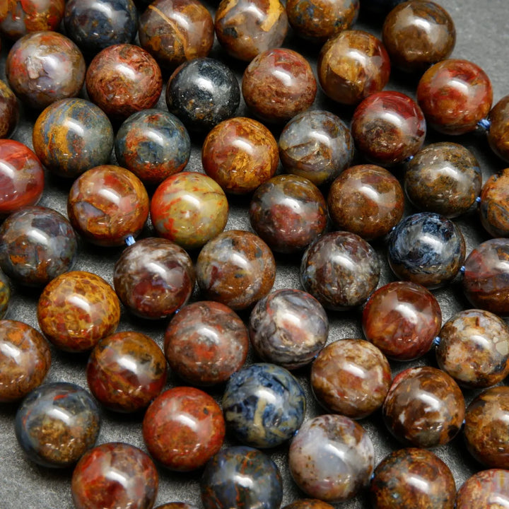 Brown, blue, and red round polished pietersite beads.