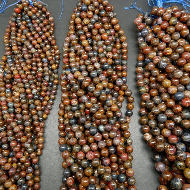 Brown, blue, and red round polished pietersite beads.