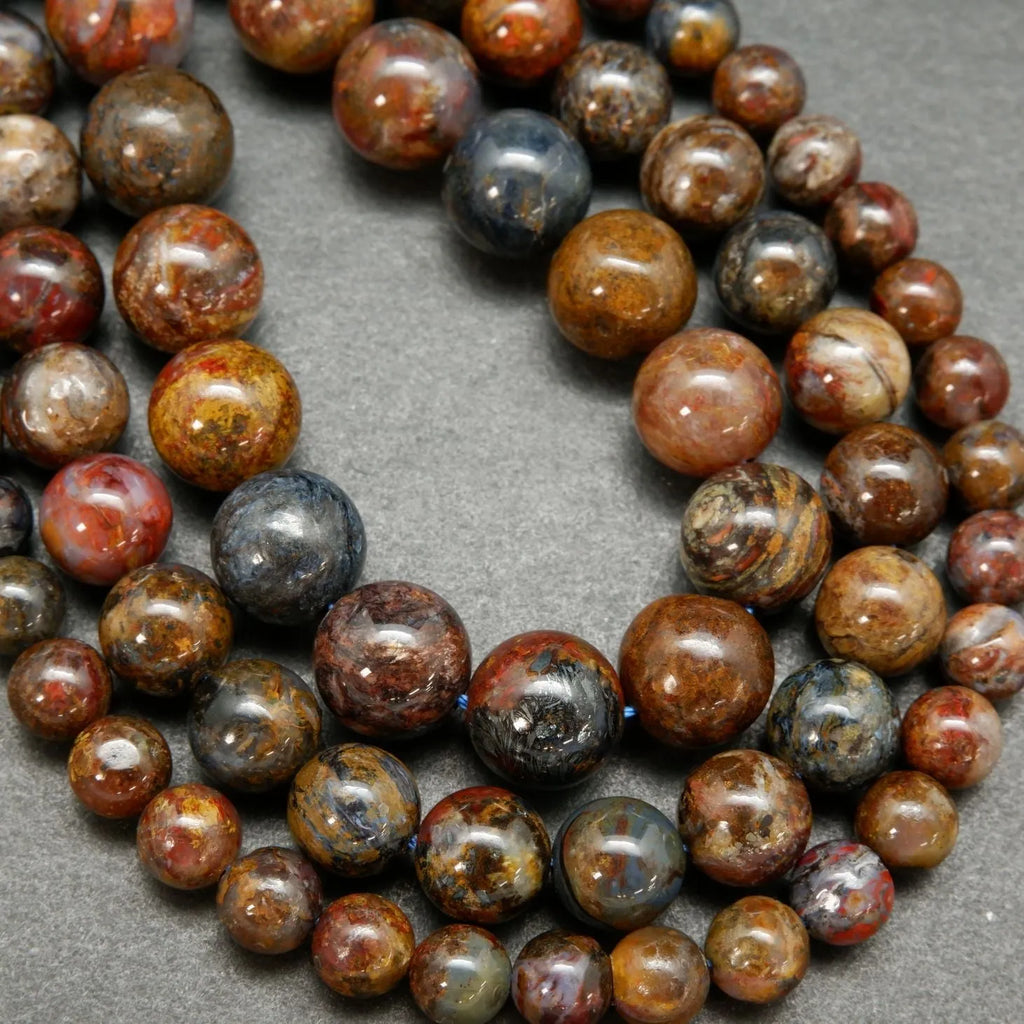 Brown, blue, and red round polished pietersite beads.