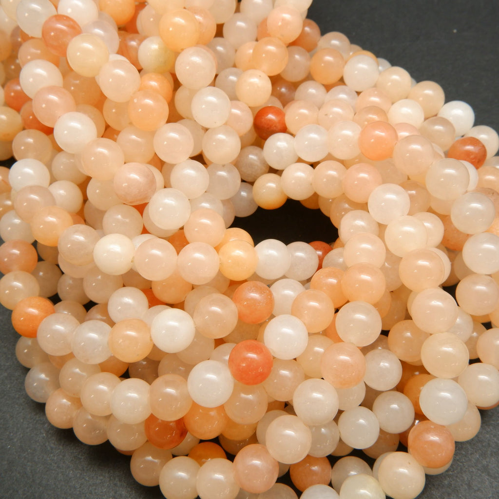 Peach Aventurine Beads showing a mix of hues from light to dark peach, with an almost orange appearance.