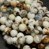 Polished round lemon chrysoprase beads with brown matrix.