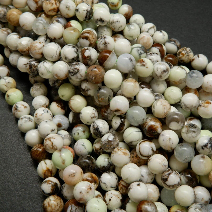 Polished round lemon chrysoprase beads with brown matrix.