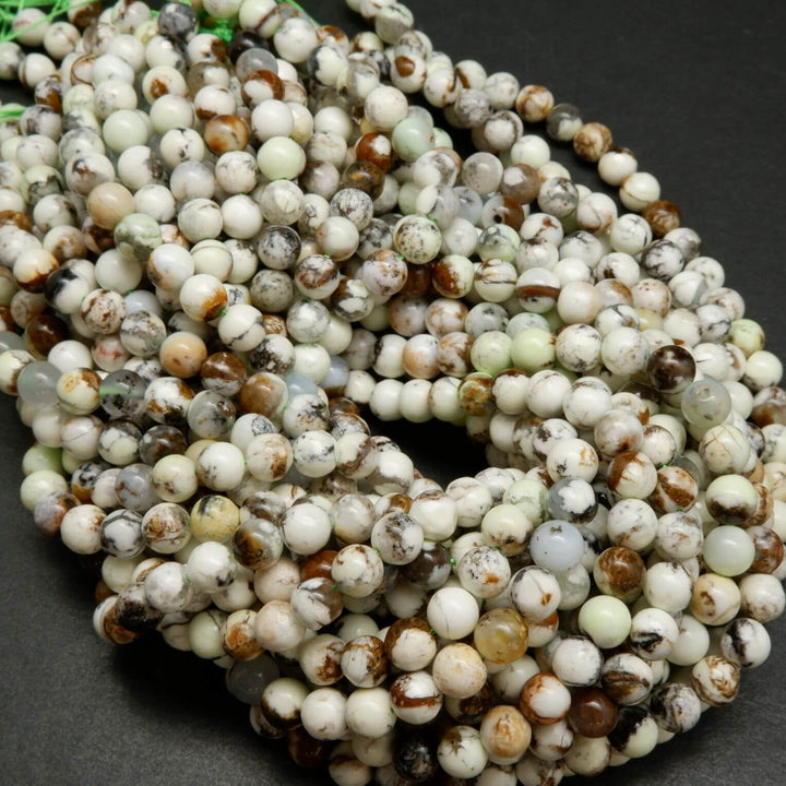 Polished round lemon chrysoprase beads with brown matrix.