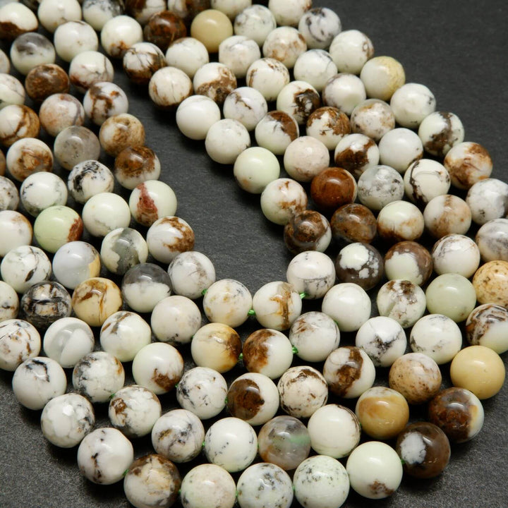 Polished round lemon chrysoprase beads with brown matrix.