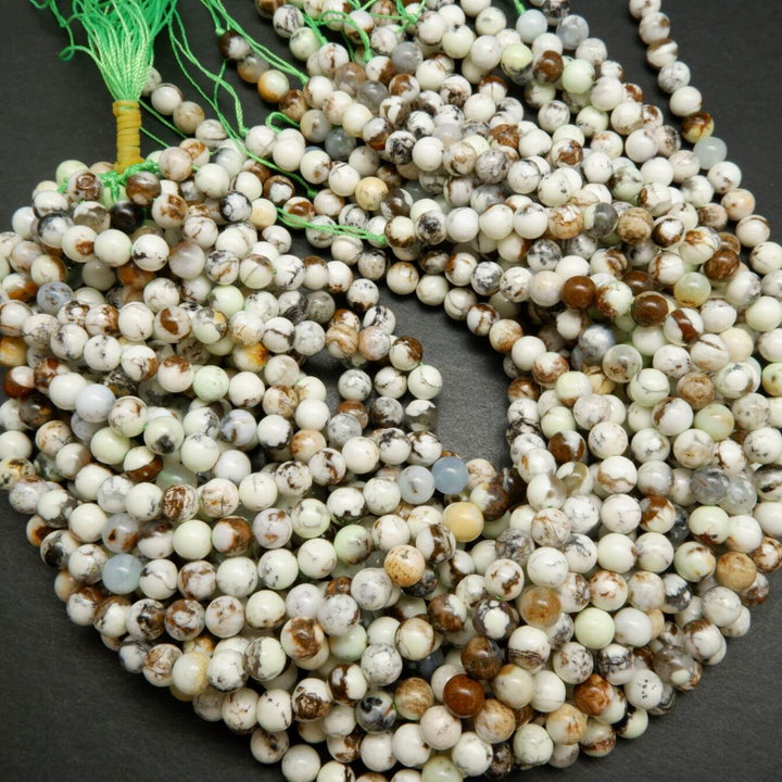 Polished round lemon chrysoprase beads with brown matrix.