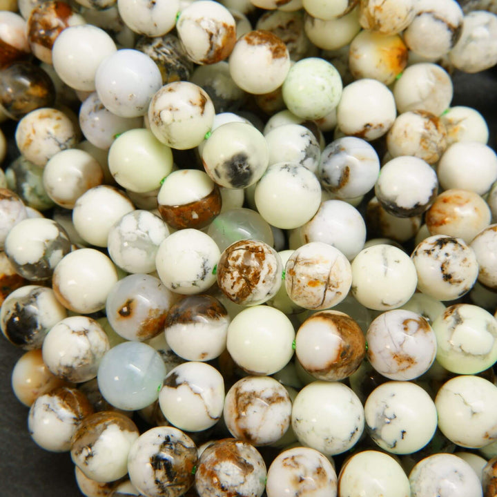 Polished round lemon chrysoprase beads with brown matrix.