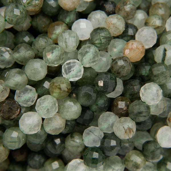 Faceted green rutilated quartz beads.