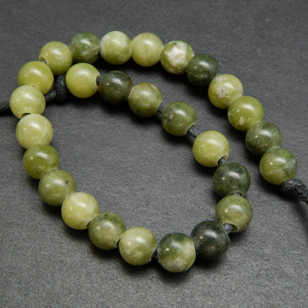 Mixed dark and light olive green hues in these olivine jade large hole round beads.