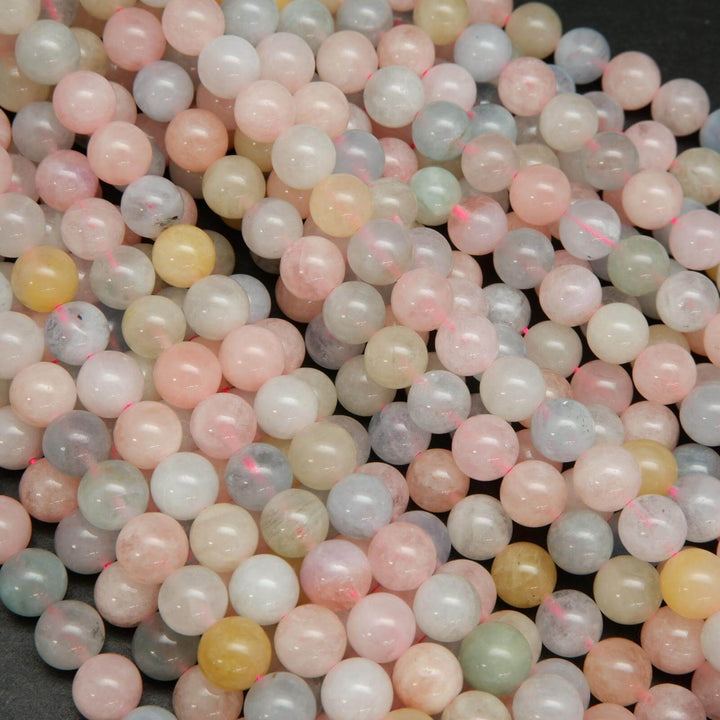 Pink, blue, green, and yellow polished round beryl beads.