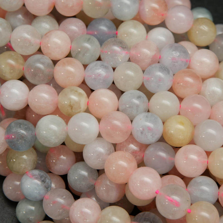 Pink, blue, green, and yellow polished round beryl beads.