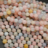 Pink, blue, green, and yellow polished round beryl beads.