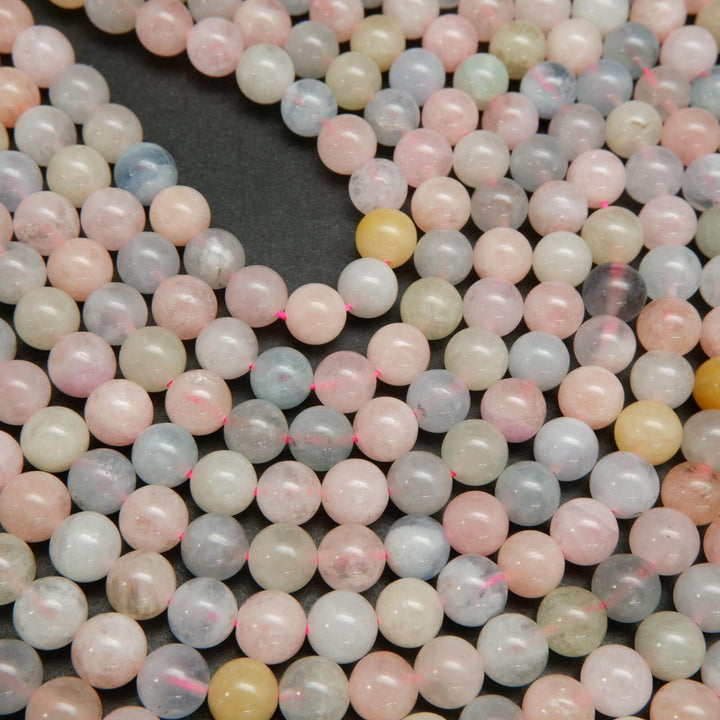 Pink, blue, green, and yellow polished round beryl beads.