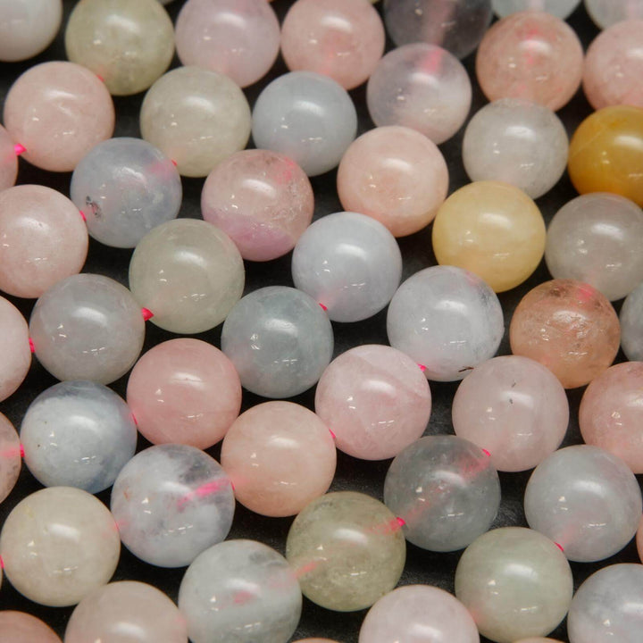 Pink, blue, green, and yellow polished round beryl beads.