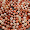Red, pink, and orange polished hematoid quartz beads.