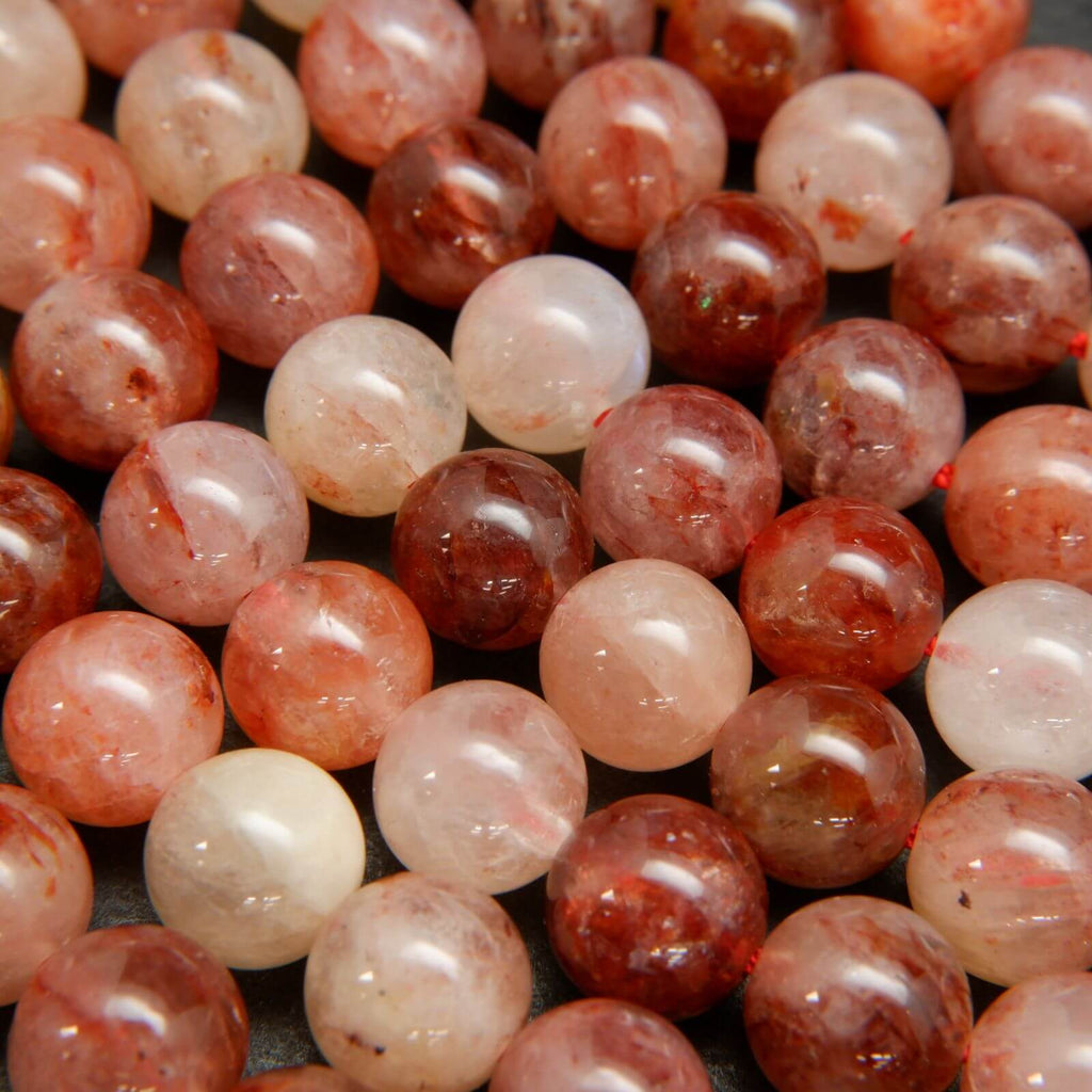 Red, pink, and orange polished hematoid quartz beads.