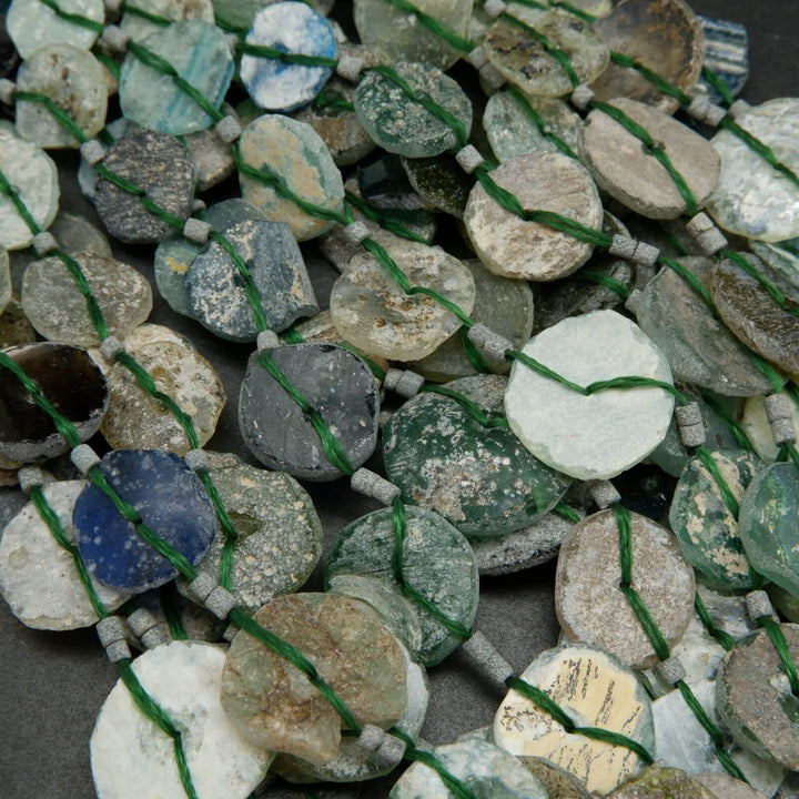 Roman glass graduated coin shape beads.