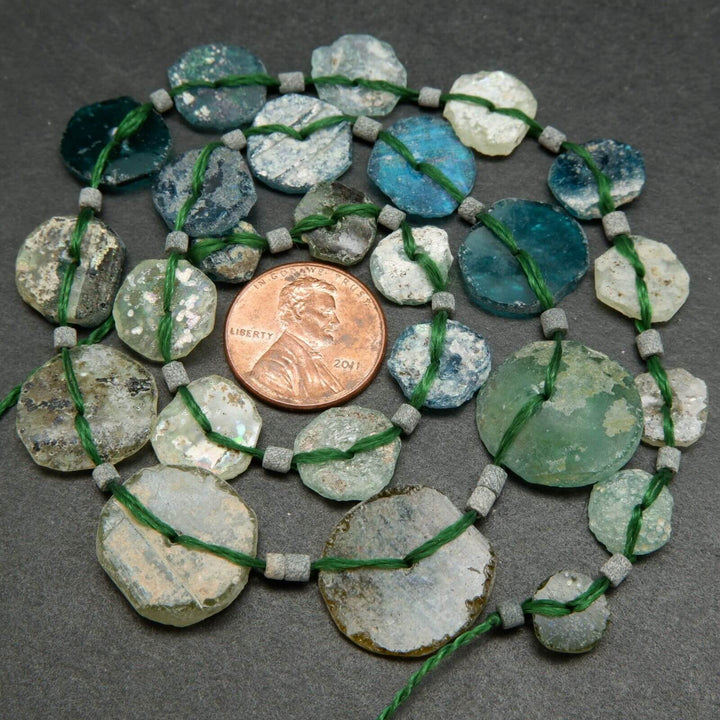 Roman glass graduated coin shape beads.