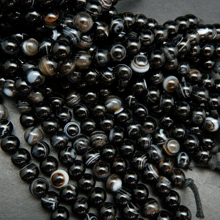 Black banded sardonyx agate large hole beads. Black polished round beads with white rings.