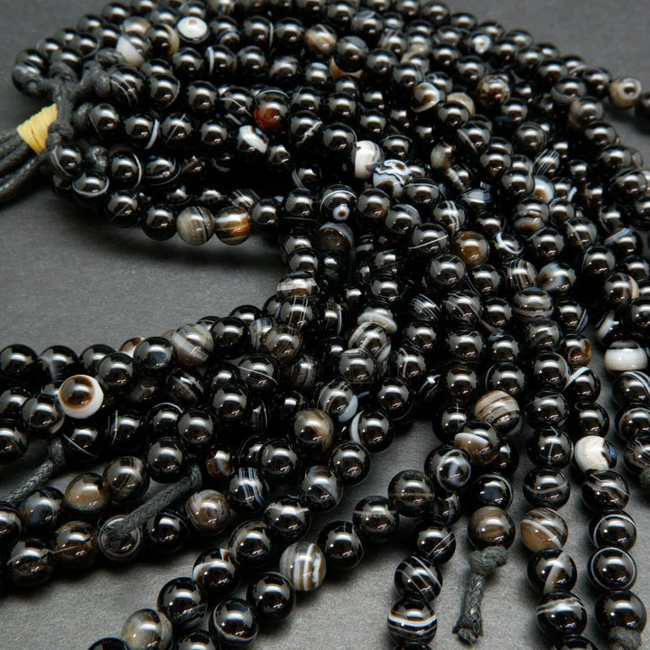 Black banded sardonyx agate large hole beads. Black polished round beads with white rings.