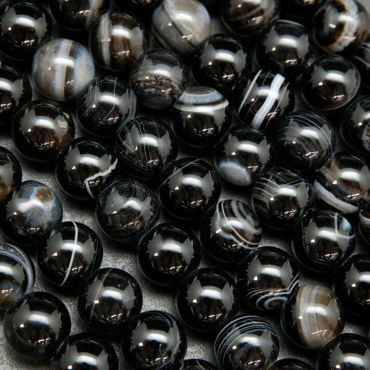 Black banded sardonyx agate large hole beads. Black polished round beads with white rings.
